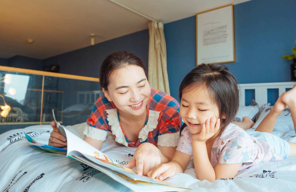 deux soeurs lisent sur le lit