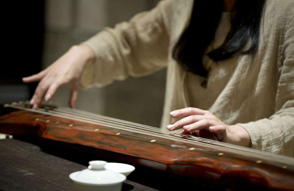 femme jouant du gǔq&iacute;n, la cithare chinoise &agrave; 7 cordes
